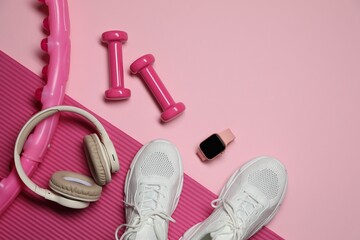 Dumbbells, watch and other fitness equipment on pink background, flat lay. Space for text