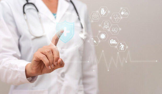 Close up of Doctor using virtual hologram interface showing health insurance and medical icons