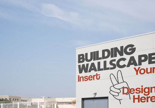 Wallscape on a large warehouse building under a clear sky in an industrial area.
