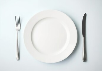 White plate with knife and fork on a white background, top view.