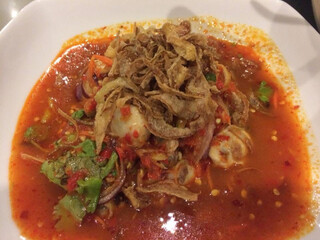 Thai spicy Oysters salad mixed with oil chili paste vegetable and herb in white plate	