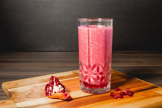 A piece of Pomegrenade with a glas of Pomegrenade juice.