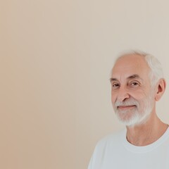 Obraz premium Happy retired man with white hair and beard smiling on neutral background