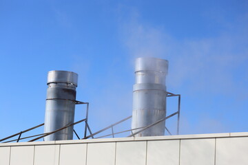 Obraz premium Heating unit with steam coming out of its vents against a backdrop of blue sky
