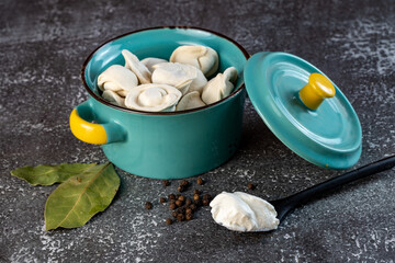 Meat dumplings - russian pelmeni in a bowl on a dark background