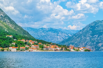 A peaceful view of the coastal town of Prcanj, Montenegro, with traditional houses and the stunning...