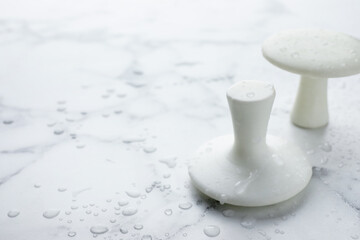 Wet spa stones on white marble table, closeup. Space for text