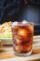 Cola soft drink with ice cubes and papaya salad spicy Thai food