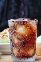 Cola soft drink with ice cubes and papaya salad spicy Thai food