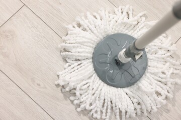 String mop on wooden floor indoors, above view. Space for text
