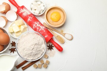 Rolling pin and different ingredients on white table, flat lay. Space for text