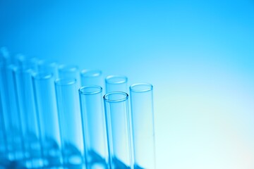 Test tubes on light blue background, space for text. Laboratory glassware