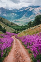 Vibrant purple flowers line a dirt road, set against a stunning mountain range backdrop, creating a picturesque natural scene in the mountains.