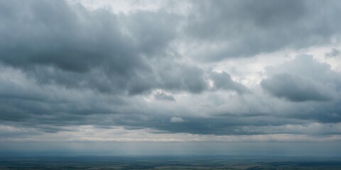 Dark stormy clouds covering the sky over a distant horizon with muted colors and an atmosphere of impending weather conditions.