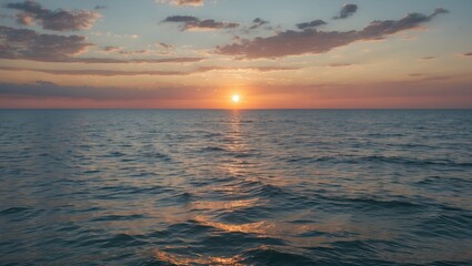 Obraz premium Sunset over calm ocean waters with colorful sky and clouds reflecting in the water surface at twilight.