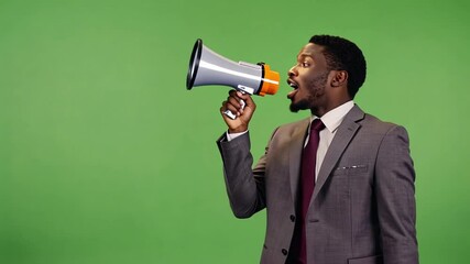 An African American businessman holds and speakis on a megaphone against a green backdrop. Concept of confident announcement and leadership. - Powered by Adobe