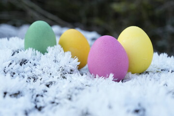 Farbige Ostereier mit Eiskristallen und Schnee