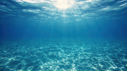 Obraz premium Sunlight filters through the azure water, creating a serene interplay of light and shadow in the tranquil ocean depths.
