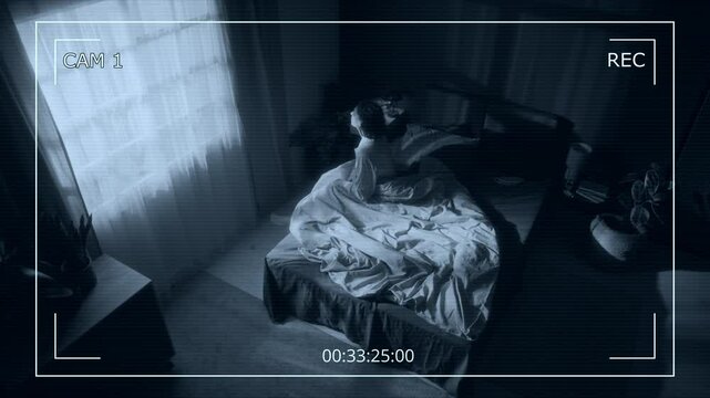 CCTV footage of young woman standing up from her bed in middle of night and sleepwalking around her bedroom