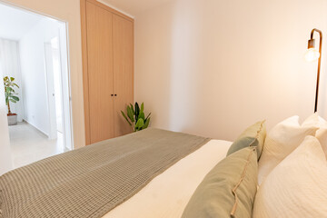 a small bedroom with fitted wooden wardrobe in Mediterranean holiday apartment 
