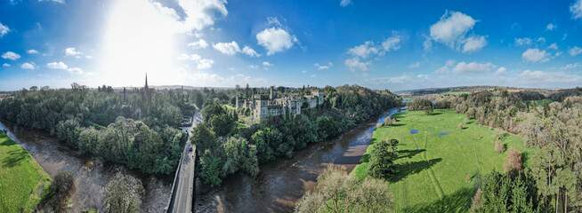 Aerial view of Lismore Castle, Ireland, showcasing its stunning Gothic architecture and scenic riverside location