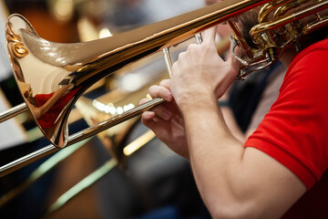 Fototapeta premium Close-up of musician's hands playing trombone