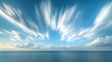 A panoramic view showcasing a vibrant blue sky adorned with fluffy clouds above a tranquil ocean, embodying serenity and natural beauty.