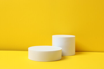 White podiums on yellow background
