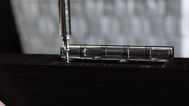tighten a screw with a screwdriver, door hinges