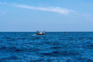 Two traditional Thai long-tailed boats are sailing towards each other in Andaman Sea, Thailand