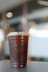 A takeaway cup of ice black coffee on table, concept to advertising beverage