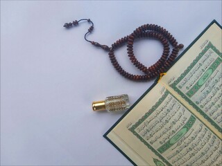 Al Quran, Tasbih and Perfume in the month of Ramadhan in a flat lay portrait