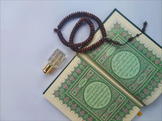 Al Quran, Tasbih and Perfume in the month of Ramadhan in a flat lay portrait