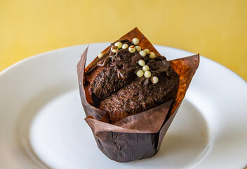 a delicious, nicely decorated homemade chocolate cupcake. a dark cupcake with chocolate filling inside and sprinkles.