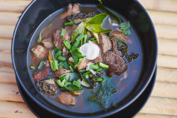 Upia, an Isan dish made from beef on a black plate.