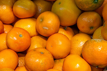 a lot of tangerines in the store, fruit in a pile in the box