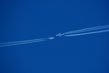 two planes in the sky, two airplane tracks in the blue sky, contrails