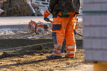 road workers at work. road and construction workers in orange vests. earthworks being done in the...