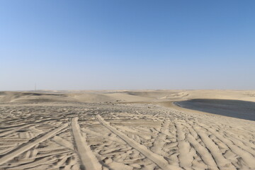 Naklejka premium Tracks on sand dunes - Inland Sea, Qatar