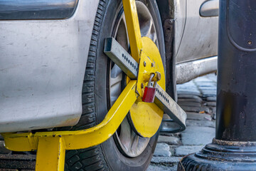a lock placed on a car wheel by the services. a car blocked by the city guard and police for...