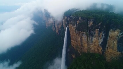 Majestic Waterfall Cascades Down Cliffside Amidst Clouds and Lush Greenery