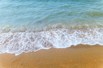Soft blue ocean wave on clean sandy beach. Copy Space. Background