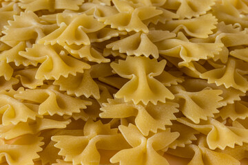 Side view ,  close-up of a raw italian durum wheat farfalle pasta .
