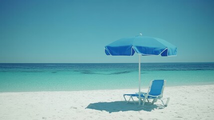 A blue chair and an umbrella sit on the sandy beach beside the ocean, creating a serene and inviting atmosphere for relaxation.