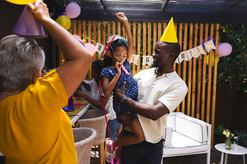 Celebrating birthday, diverse family enjoying in garden party with balloons and decorations