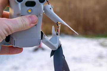 man holding and showing crashed drone. damaged propellers and engine in unmanned aerial vehicle. broken plastic arms with engines.
