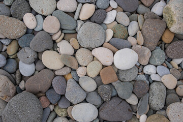 Colorful pebbles on beach. Textures and patterns of smooth round pebbles stones. Top view