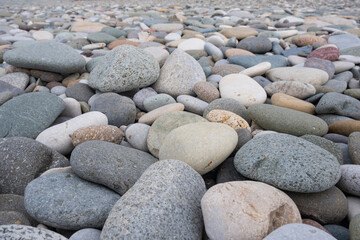 Colorful pebbles on beach. Textures and patterns of natural smooth round pebbles stones in seashore. Close up