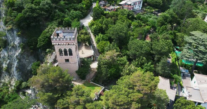 Aerial view of a historic tower nestled amidst the verdant landscape of Monterosso al Mare, Cinque Terre, Italy surrounded by forest