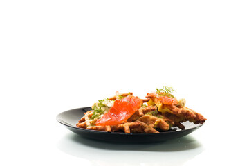 vegetable potato waffles with spread and lightly salted red fish in a plate